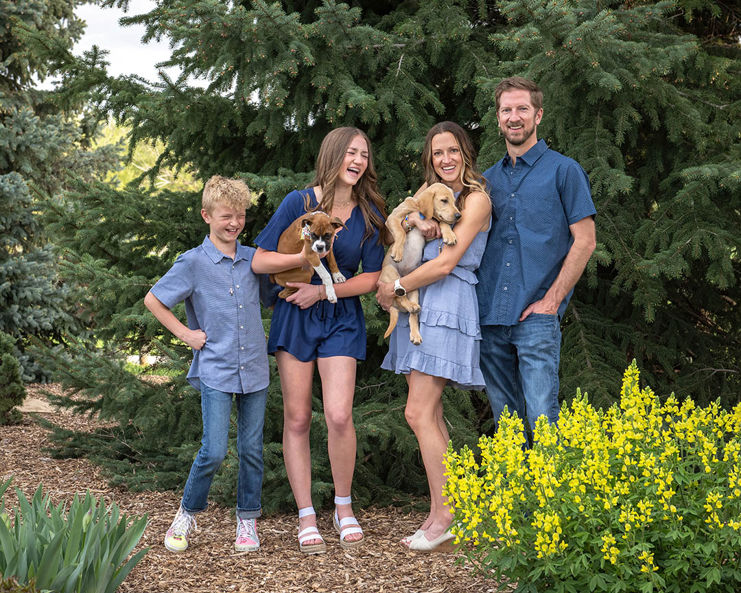 Family posing with two puppies