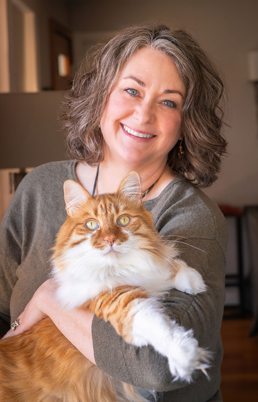 Woman holding a fluffy orange and white cat